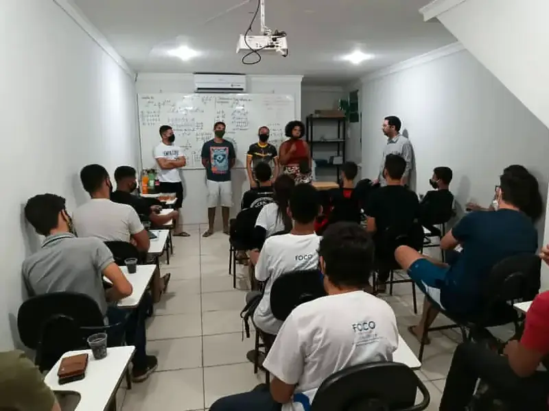Sala do Foco cheia, alunos sentados olhando para os professores diante do quadro