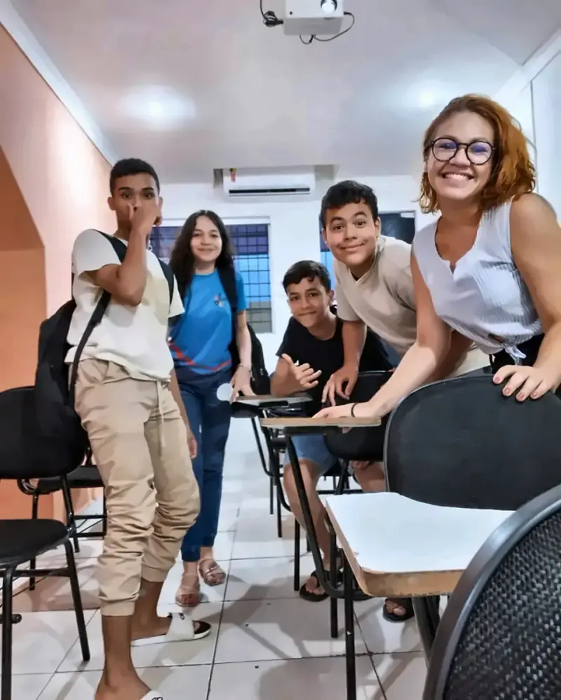 Alunos do Foco sorrindo para a foto entre as carteiras da sala
